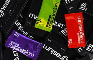 Colorful magnesium supplement packages on a black background